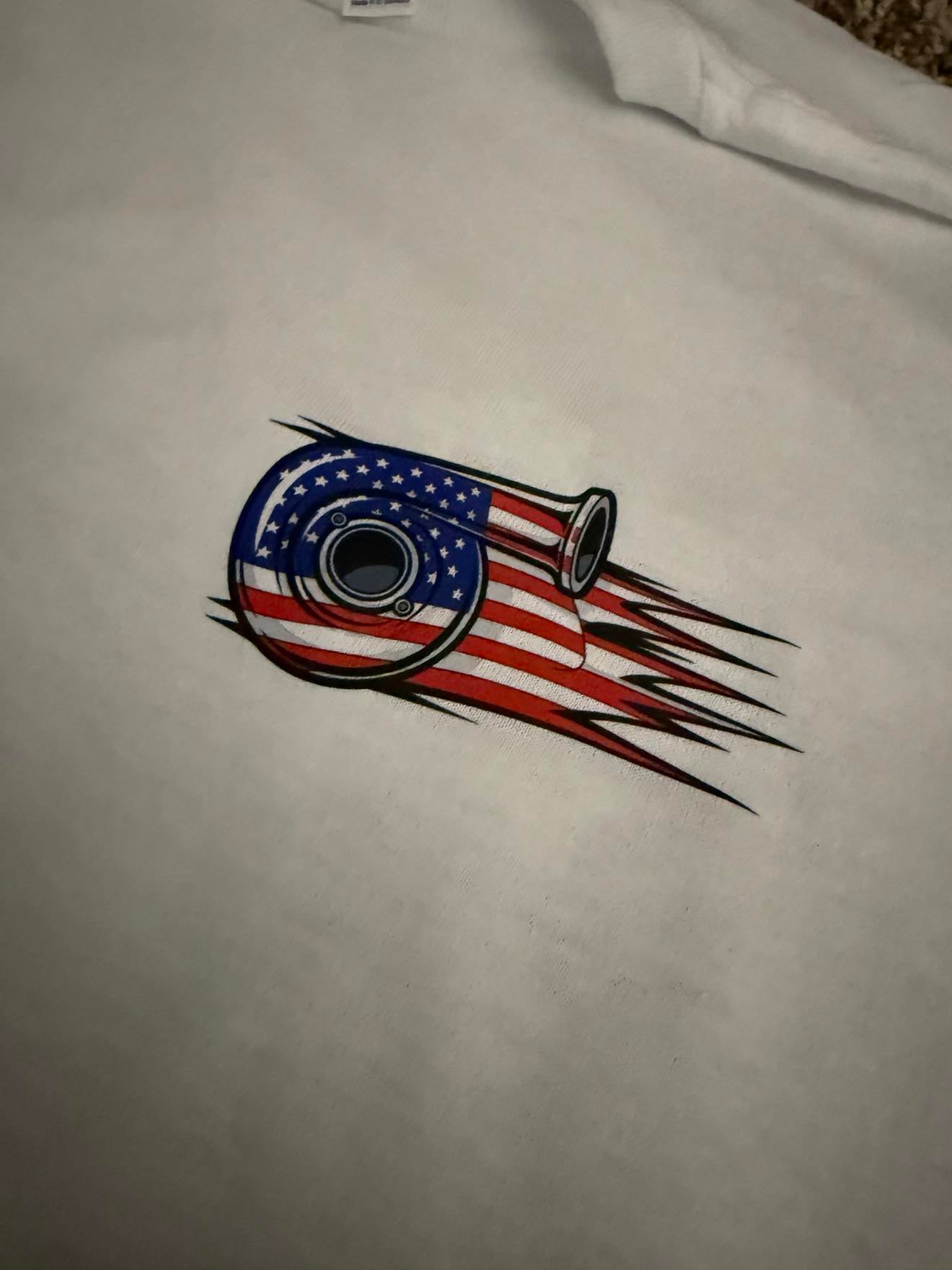 White t-shirt with a graphic design featuring an American flag and a bullseye on a plain background.
